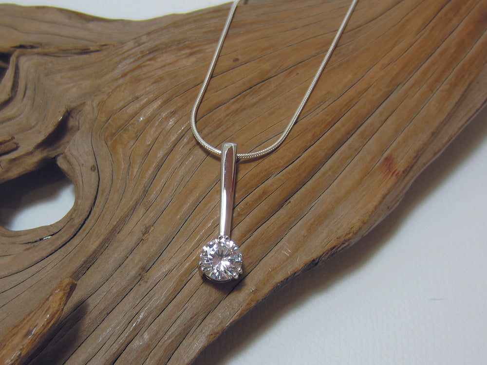 Sparkly 8mm cubic zirconia stone set at the bottom of a simple sterling silver bar. 30mm long in total. It is shown here on a fine snake chain. 925 Silver Canterbury