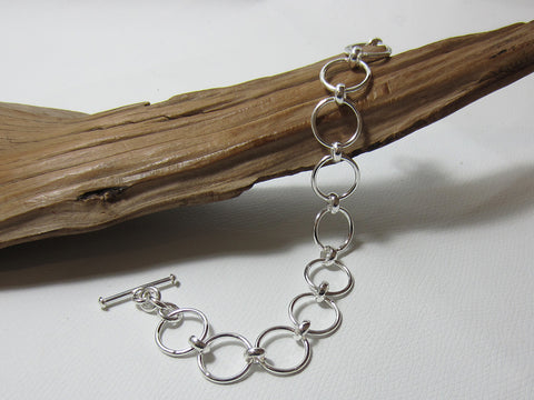 Simple but effective sterling silver bracelet made up of 15mm diameter circle links. It is 19cms long including the t-bar fastener. It weighs around 13.5 grams and carries a full set of UK Hallmarks. 925 Silver Canterbury