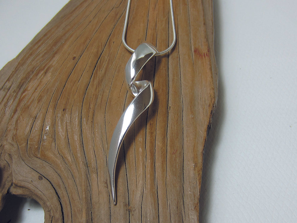 A long, twisty sterling silver pendant which is 53mm long and 12mm wide. It is shown here on a fine snake chain. 925 Canterbury