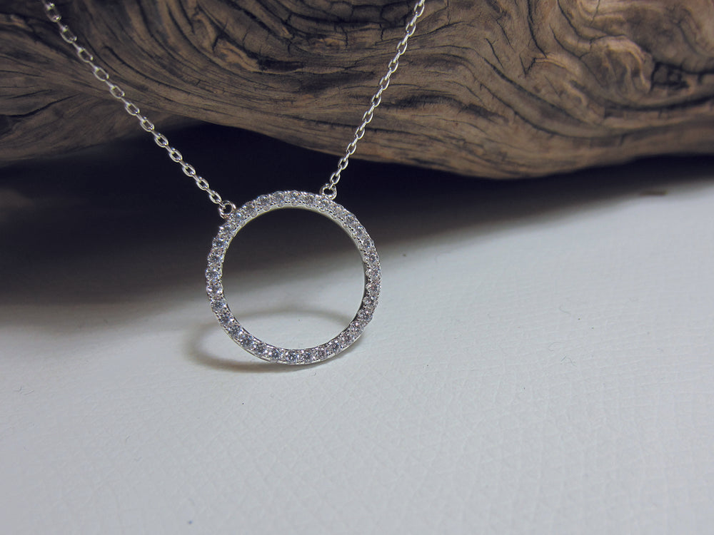 A simple, sterling silver and cubic zirconia set 19mm diameter circle hanging from simple chain which can be worn at either 41 or 45cm. This piece is rhodium plated to reduce the need for cleaning.
