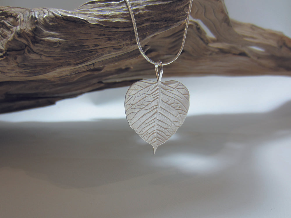 Nicely detailed, matt finish sterling silver leaf shaped pendant, shown here on a fine snake chain. It measures 28mm across and 40mm high including the bail. 925 Silver Canterbury