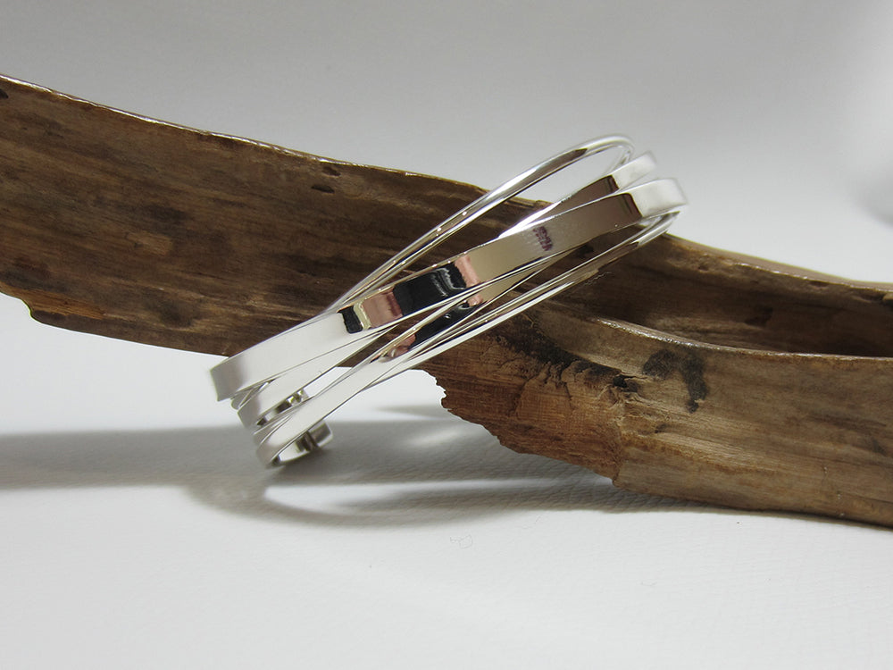 A striking, sterling silver multi strand cuff which is about 15mm deep and 60mm across. It weighs around 29 grams and carries a full set of UK Hallmarks. 925 Silver Canterbury