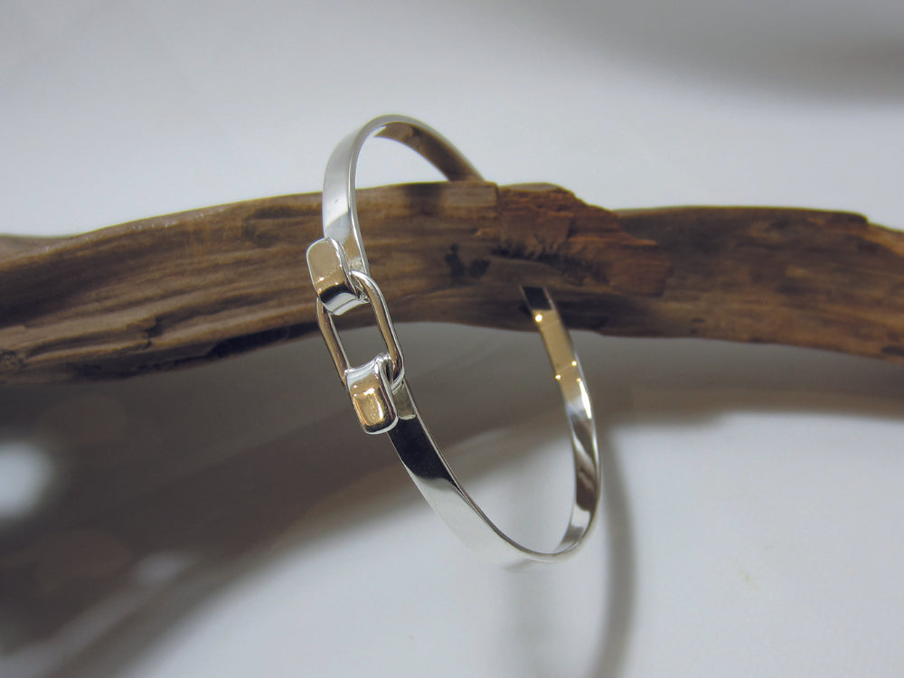 The belt buckle style clasp allows the bangle to open so it easily slips over the hand. The bangle sterling silver measures 65mm across at it's widest point and is 5mm deep, it weighs 16.6 grams and carried a full set of UK Hallmarks. 925 Silver, Canterbury