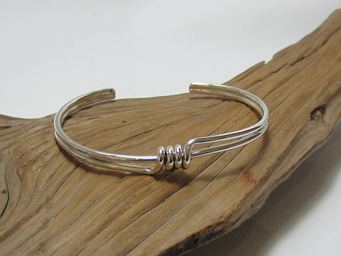 Slim cuff-style bangle with a simple coiled decoration. The bangle is 63mm across and weighs around 10 grams so carries a full set of UK Hallmarks. 925 Silver Canterbury