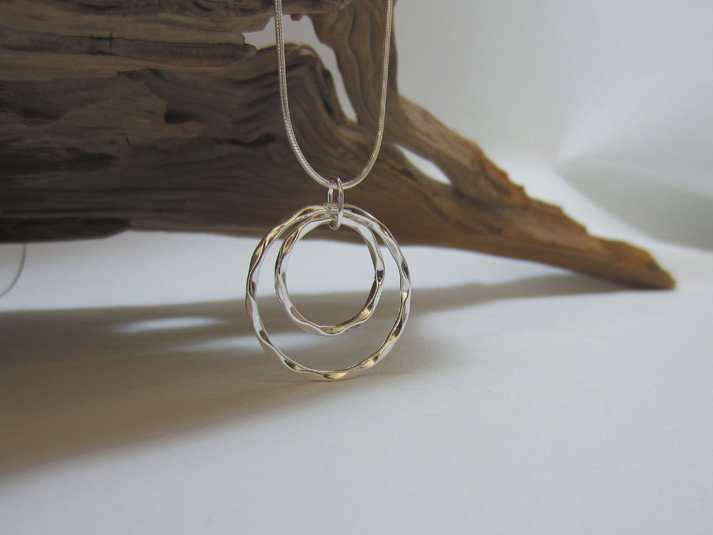 This eye-catching, sterling silver pendant measures 30mm across and is shown here on a fine snake chain. The crinkled edges catch the light nicely. 925 Silver, Canterbury