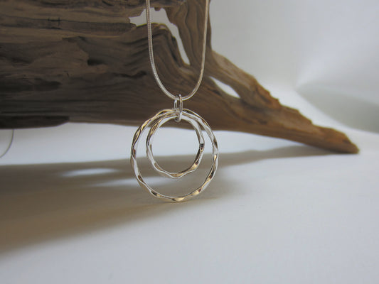 This eye-catching, sterling silver pendant measures 30mm across and is shown here on a fine snake chain. The crinkled edges catch the light nicely. 925 Silver, Canterbury