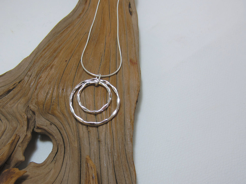 This eye-catching, sterling silver pendant measures 30mm across and is shown here on a fine snake chain. The crinkled edges catch the light nicely. 925 Silver, Canterbury