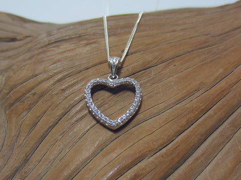 Beautifully detailed sterling silver heart shaped pendant with with cubic zirconias. It is 20mm long including the bale which is also set with stones. It is shown here on a medium curb chain. 925 Canterbury