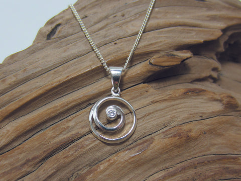 Cute sterling silver spiral pendant with a small cubic zirconia set in the centre. It measures 15mm across and is shown here on a medium curb chain. 925 Canterbury