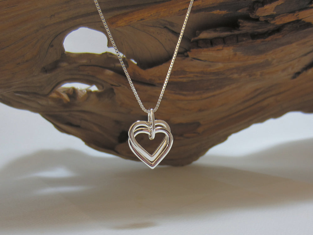 A two nestling hearts which are 17mm wide hang from a 16" fine box chain which has a 2" extender if required. 925 Silver, Canterbury