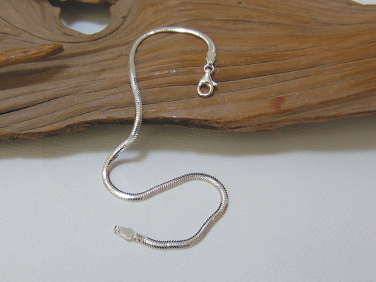 This flat oval, sterling silver snake chain bracelet is 19.5cms long and 3mm wide. 925 Silver Canterbury