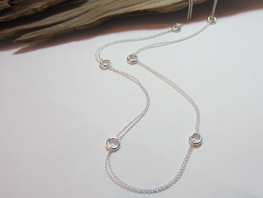 This sterling silver necklace measures 80cm or 32" long. It is made up of 8mm doughnut shpaed beads linked by a double length of fine trace chain. 925 Silver Canterbury