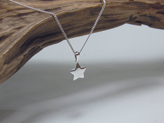Slightly domed plain sterling silver star pendant. It is measures 10mm across and is shown here on a medium curb chain. 925 Silver Canterbury