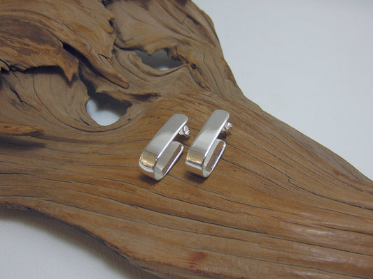 Simple, sterling silver j hoop which measures 24mm long and 6mm wide. 925 Canterbury