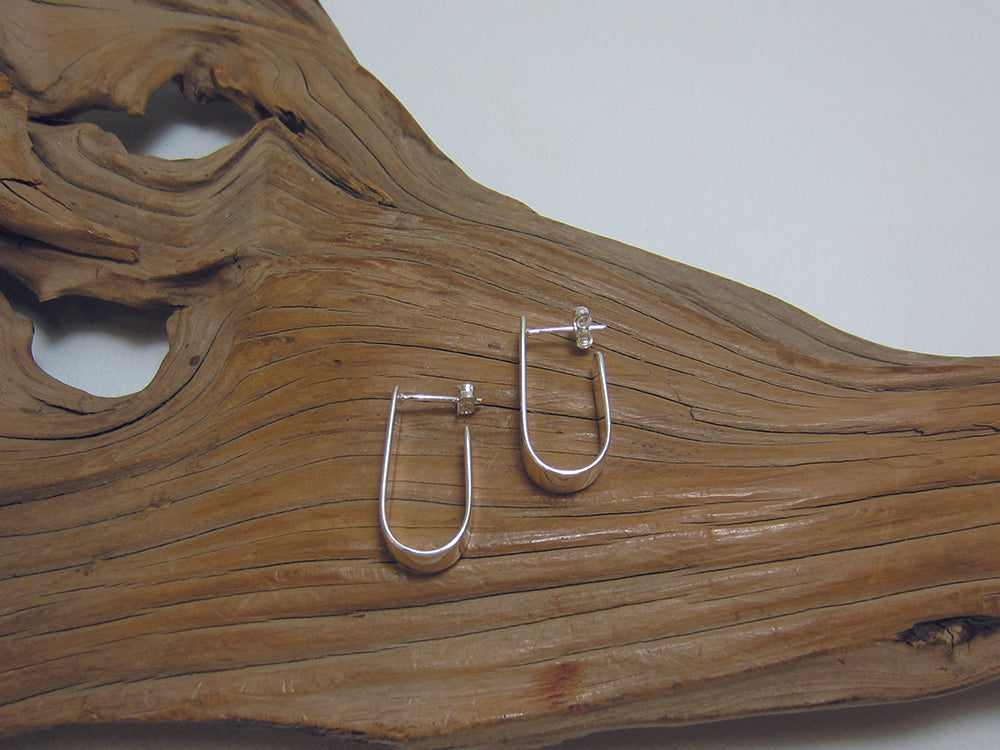 Simple, sterling silver j hoop which measures 24mm long and 6mm wide. 925 Canterbury