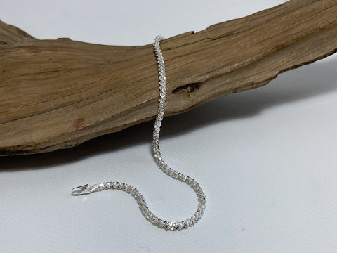 A cleverly designed, sterling silver bracelet which sparkles almost as if it were set with stones. It is 19.5cm long and 3mm wide. 925 Silver Canterbury