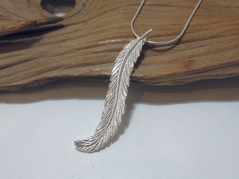 Lovely sterling silver feather pendant which is 58mm long. It is shown here on a fine snake chain.