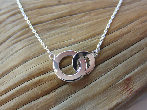 Simple and stylish, this sterling silver interlocking circles necklace measures 18" long and the larger circle measures 12mm across. 925 Silver Canterbury