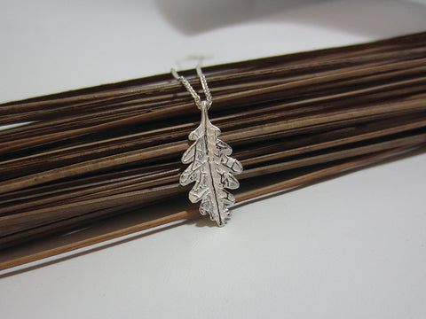 A symbol of courage and power this sterling silver oak leaf pendant measures 25mm ong and 15mm wide. It is shown here on a spiga chain which really complements the slightly satin finish. 925 Silver Canterbury