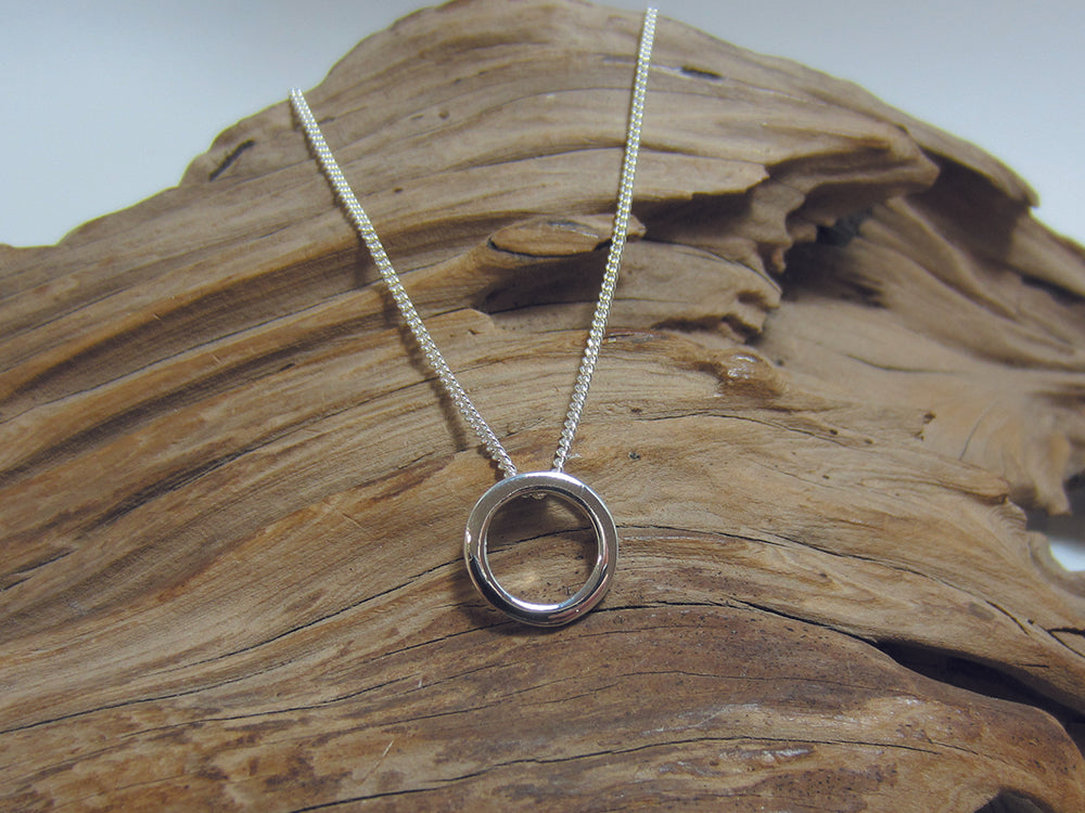 Simple, understated sterling silver pendant which measures 12mm across. It is seen here on a medium curb chain. 925 Canterbury