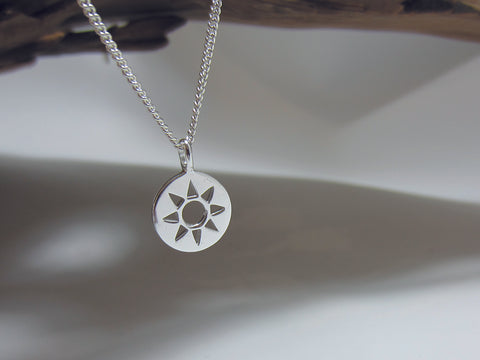 Stylised, sterling silver sun pendant which measures 12mm across. It is shown here on a medium curb chain. 925 Canterbury