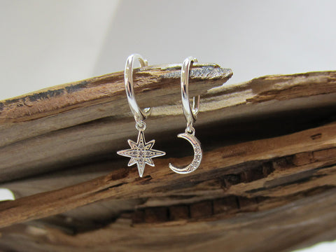 12mm sterling silver huggies with a star and moon charm, each is set with cubic zirconias for a bit of extra sparkle. 925 Canterbury